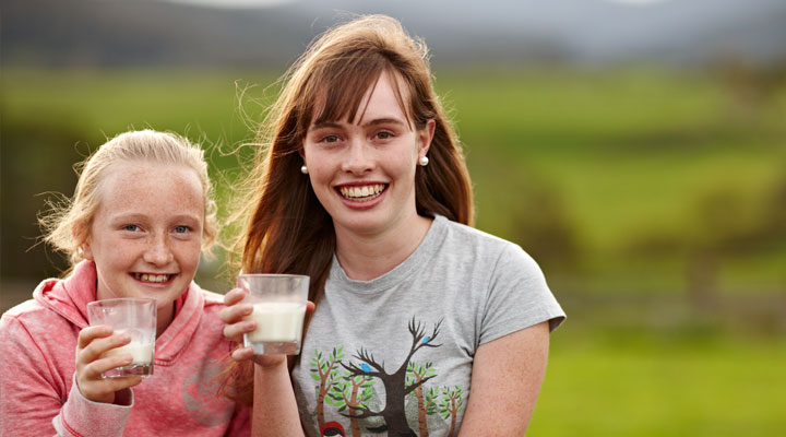 Teenagers holding a glass of milk