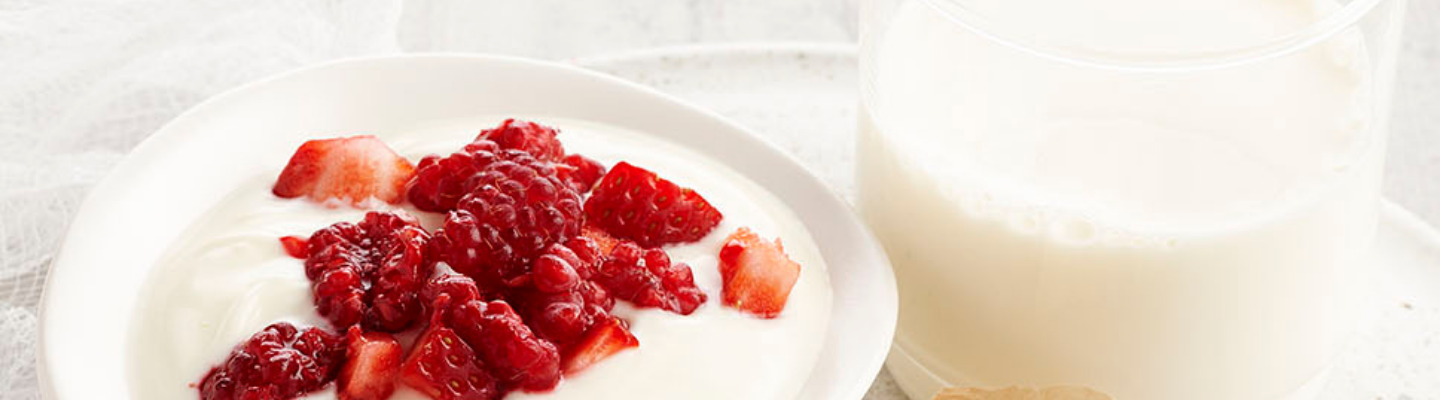 Glass of milk, yogurt with red berries and a slice of cheese