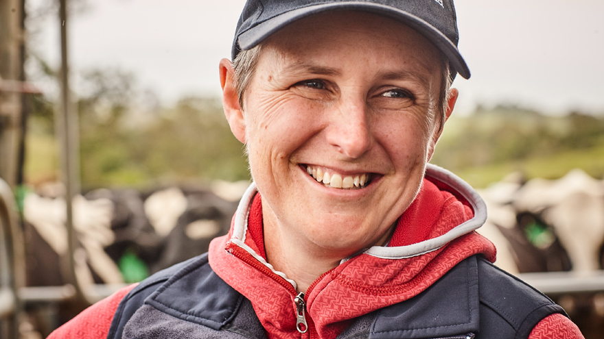 Close up of woman wearing a Dairy Australia hat, cows in distance